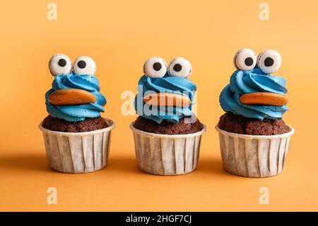 Gustosi cupcake divertenti per la festa di Halloween su sfondo colorato Foto Stock