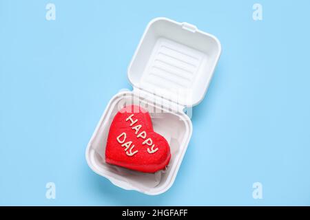 Pranzo al sacco in plastica con gustosa torta bento su sfondo blu Foto Stock