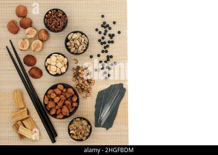 Trattamento di agopuntura cinese con aghi, erbe e spezie con pillole nere, zhi bai di huang, utilizzato per aumentare i livelli di chi. Assistenza sanitaria alternativa. Foto Stock