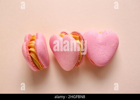 Gustosi amaretti a forma di cuore su sfondo beige Foto Stock