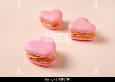 Gustosi amaretti a forma di cuore su sfondo beige Foto Stock