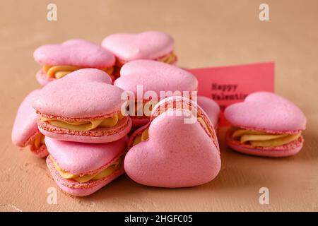 Gustosi amaretti a forma di cuore su sfondo beige Foto Stock