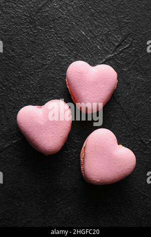 Gustosi amaretti a forma di cuore su sfondo nero Foto Stock