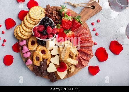 Piatto di formaggi o snack per San Valentino con biscotti e frutta Foto Stock