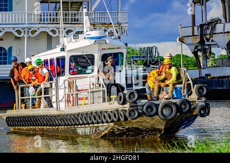 I lavoratori si riuniscono mentre la Tugboat Miss D arriva a riva, 1 luglio 2021, a Bayou la Batre, Alabama. Foto Stock