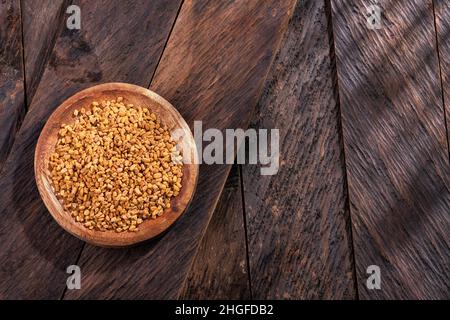 Semi di fenugreek nella ciotola di legno - cibo sano Foto Stock