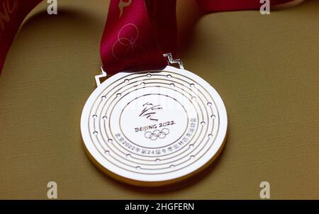 14 gennaio 2022, Pechino, Cina. Medaglia d'oro dei XXIV Giochi Olimpici invernali su sfondo giallo. Foto Stock