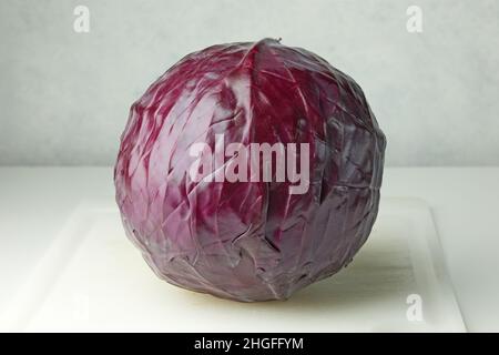 cavolo viola fresco su tavola bianca da taglio da cucina Foto Stock