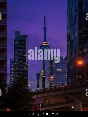 Ago di Toronto. Il nigt Toronto skyline visto tra i grattacieli con l'iconica torre CN guglia che piercing magnifico cielo Foto Stock