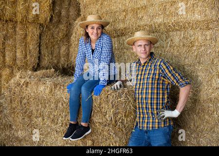 Due lavoratori assunti che parlano durante la pausa tra un lavoro e l'altro in azienda agricola Foto Stock