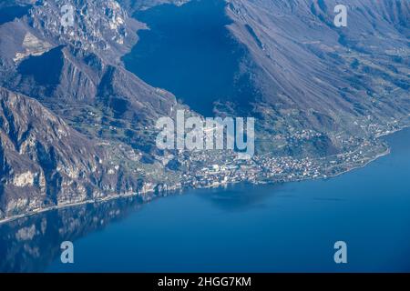 Scatto aereo, da un piccolo aereo, del borgo lacustre di Marone sul lago di Sebino, girato alla luce invernale, Brescia, Lombardia, Italia Foto Stock