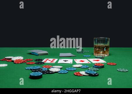 Tavolo verde nel casinò con carte da poker e chip. Foto Stock