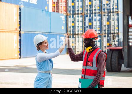 Felice dare mani due uomo d'affari e ingegnere che lavorano controllo di carico contenitori scatola da carico nave da trasporto Cargo per l'esportazione di importazione. Spedizione in banchine Foto Stock