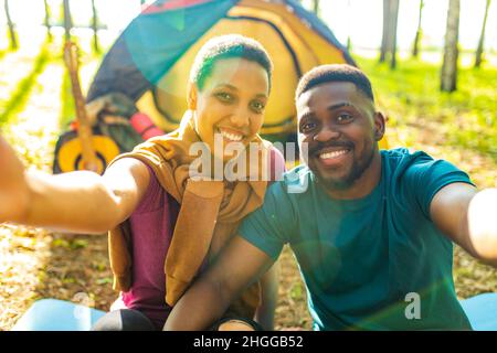 afro latin coppia in tenda prendendo selfie con smartphone moderno Foto Stock