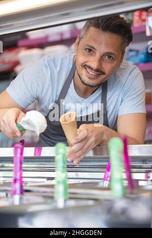 gelateria che serve un gelato Foto Stock