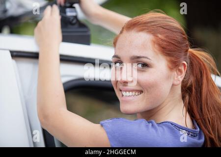 mature donna ciclista prendere mountain bike in auto Foto Stock