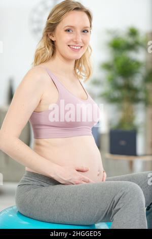 la donna incinta atletica entra per lo sport con la palla Foto Stock