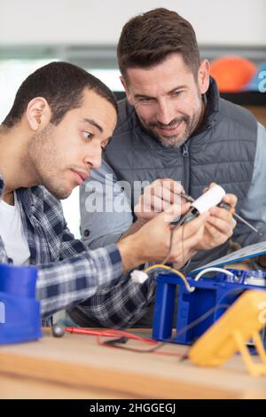 Elettricista con apprendista lavorare nella nuova casa Foto Stock