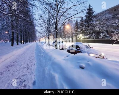 Mosca. Russia. Gennaio 18, 2022. Mattina presto in città dopo nevicate e bizzard. Le auto coperte di neve sono parcheggiate su una strada coperta di neve a Mosca in enormi nevicate. Foto Stock