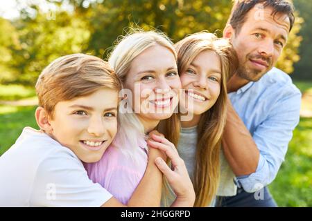 Felice genitori e due bambini come una piccola famiglia armoniosa in un viaggio estivo Foto Stock