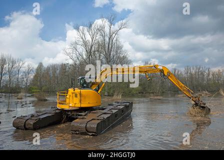 Escavatore a pala in pianura allagata, lavori di costruzione per la protezione contro le inondazioni, Belgio, Fiandre Orientali, Berlare, Berlare Broek Foto Stock