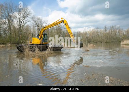 Escavatore a pala in pianura allagata, lavori di costruzione per la protezione contro le inondazioni, Belgio, Fiandre Orientali, Berlare, Berlare Broek Foto Stock