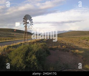 Mulino a vento e pompa d'acqua in paesaggio secco Foto Stock