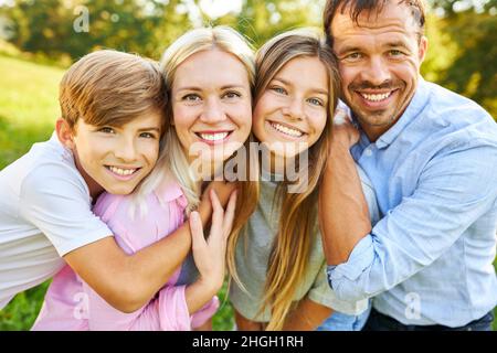 Famiglia felice con figlia e figlio in piedi fianco a fianco in estate nella natura Foto Stock