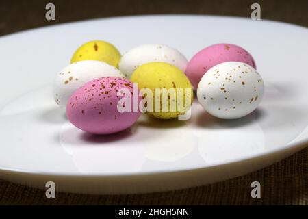 Uova di Pasqua multicolore sul piatto bianco. Foto Stock