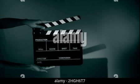 Immagini sfocate di ardesia filmato o bordo clapper. La mano tiene in studio film vuoti che fanno clapperboard su sfondo a colori per riprese di film o reco Foto Stock