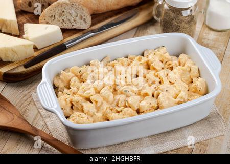 Macaroni e formaggio in casseruola bianca su tavola di legno Foto Stock