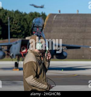 Un Airman dell'aeronautica degli Stati Uniti assegnato all'unità di manutenzione dell'aeromobile 492nd comunica con un pilota alla Royal Air Force Lakenheath, Inghilterra, 18 gennaio 2022. La 48th Fighter Wing effettua operazioni di volo quotidiane per garantire che la Liberty Wing possa offrire capacità di combattimento aereo uniche quando viene chiamata dai suoi alleati della NATO. Foto Stock