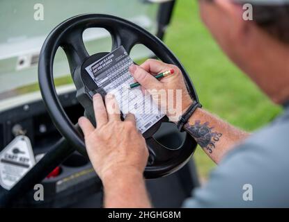 Steven Weber, 436° responsabile del supporto della forza Squadron Eagle Lanes, compila la sua scorecard durante una partita di golf intramurale al campo da golf Eagle Creek sulla base dell'aeronautica militare di dover, Delaware, 3 agosto 2021. Otto squadre di golf intramurali stanno concludendo la stagione normale e stanno preparando per i playoff nel mese di settembre. Foto Stock