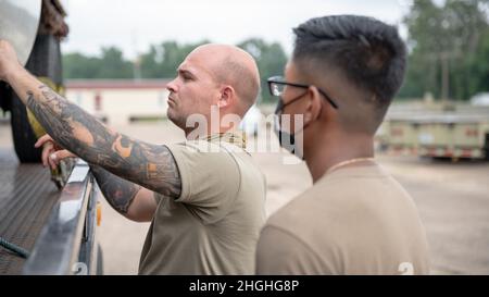 Personale Sgt. Dylan Holloway, 2nd LRS Ground Transportations training and validations Supervisor, ispeziona il lavoro svolto da Airman 1st Class Manich Prak, 2nd Logistics Readiness Squadron Ground Transportations Specialist, at Barksdale Air Force base, Louisiana, 2 agosto 2021. Holloway stava addestrando Prak su come caricare un veicolo in panne su un rimorchio a pianale. Foto Stock