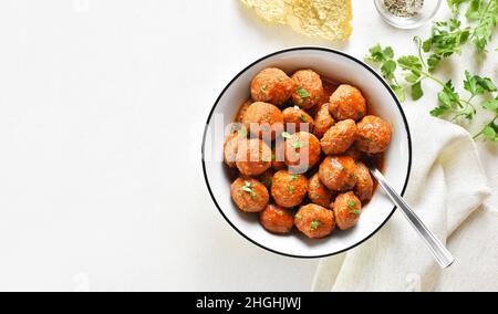 Polpette con salsa di pomodoro in ciotola su sfondo bianco di pietra con spazio copia. Vista dall'alto, piatto Foto Stock