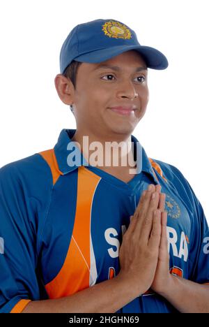 Mumbai; Maharashtra; India- Asia; 26 dicembre 2009 - Cricketer bello indiano in Namste uniforme in posizione di benvenuto sfondo bianco Foto Stock