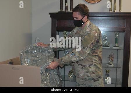 Senior Airman John Marta, 908th Airlift Wing 25th Aerial Port Squadron specialista del carico, colloca Airman Battle Uniforms in una scatola di donazione alla base dell'aeronautica di Maxwell, Alabama. Senior Airman Michael Sanchez, 25th Aerial Port Squadron, agente dei servizi passeggeri e ex CADETTO CAP, ha iniziato a raccogliere le uniformi per aiutare i giovani che desiderano diventare membri DELLA PAC ma non possono permettersi le uniformi. Foto Stock