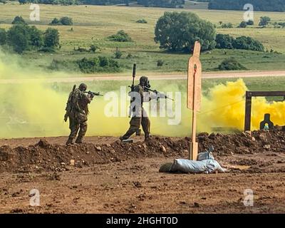 Un team di cecchini americano si muove attraverso il fumo proveniente da una trincea durante l'evento 1917 del Concorso europeo di miglior cecchino 2021 dell'8 agosto 2021 sulla Hohenfels Training Area, Hohenfels, Germania. L'EBSTC 2021 è un concorso di abilità organizzato dal comando di addestramento dell'Esercito degli Stati Uniti, diretto in Europa e Africa, che include 14 alleati e nazioni partner della NATO partecipanti alla 7th ATC's Hohenfels Training Area, 8-14 agosto. Il concorso europeo Best Sniper Team è stato ideato per migliorare la professionalità e migliorare esprit de Corps. Foto Stock