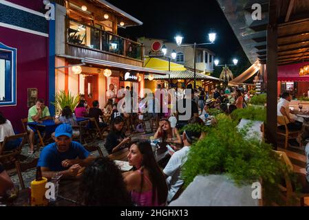 Cena all'aperto con persone che mangiano, bevono, parlano e camminano al Beco das Garrafas in Prado, Bahia, Brasile. Foto Stock