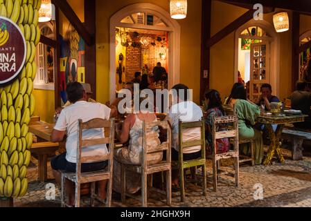 Vista posteriore delle famiglie che cenano al Restaurante Banana da Terra a Beco das Garrafas, Prado, Bahia, Brasile. Foto Stock