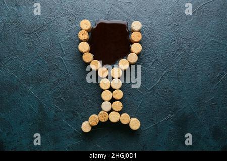 Bicchiere di sughero e vino versato su sfondo verde Foto Stock