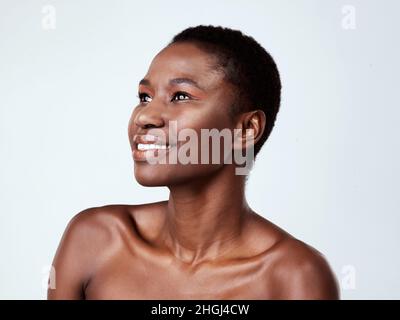 Fai risuscire la tua bellezza naturale. Studio girato di una bella giovane donna che guarda pensieroso su uno sfondo grigio. Foto Stock