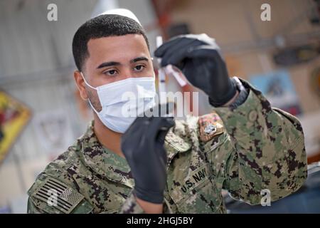 CAMP LEMONNIER, Gibuti (13 agosto 2021) U.S. Navy Hospitalman Lionel Dejesus, di Bronx, N.Y., assegnato alla Michaud Expeditionary Medical Facility, prepara forniture di vaccino COVID-19 per una somministrazione di vaccino COVID-19 su base, 13 agosto 2021. Camp Lemonnier, Gibuti (CLDJ) funge da base di spedizione per le forze militari statunitensi fornendo supporto a navi, aerei e personale che assicurano la sicurezza in tutta Europa, Africa e Sud-Ovest asiatico. CLDJ permette operazioni marittime e di combattimento nel Corno d'Africa, promuovendo nel contempo relazioni positive tra Stati Uniti e Africa. La base ospita anche COM Foto Stock