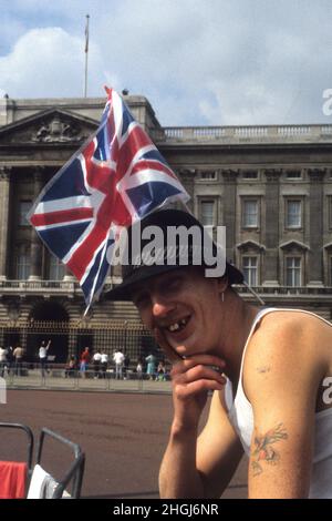 Uomo che indossa la bandiera Union Jack fuori da Buckingham Palace per le nozze del Principe Andrew e Sarah Ferguson nel luglio 23rd 1986 Foto Stock