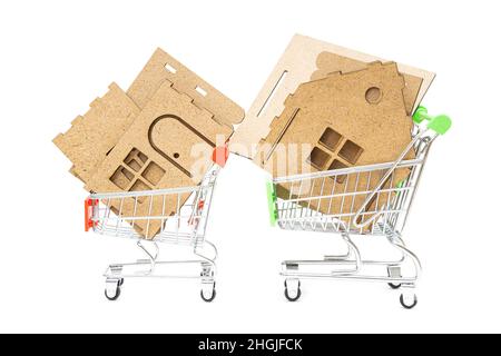 Parti di un kit modello casa in miniatura in due piccoli carrelli per lo shopping isolato su bianco. Acquisto di una casa prefabbricata. Foto Stock