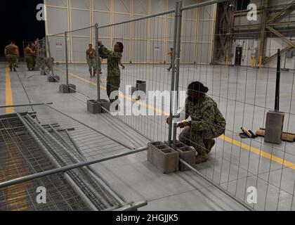 210821-N-OX321-1012 STAZIONE AERONAVALE DI SIGONELLA, ITALIA (AGOSTO 21, 2021) Seabees, assegnato al Dipartimento dei lavori pubblici della Stazione aerea navale di Sigonella, installa divisori in un hangar per creare uno spazio multifunzionale a bordo della Stazione aerea navale di Sigonella per il supporto della missione del Dipartimento della Difesa per facilitare la partenza e il trasferimento in sicurezza dei cittadini statunitensi, destinatari del visto speciale di immigrazione, E popolazioni afghane vulnerabili provenienti dall'Afghanistan, 21 agosto 2021. Foto Stock