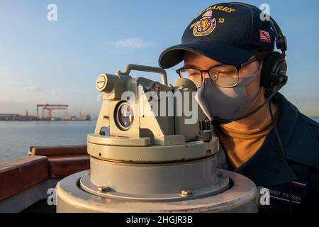 YOKOSUKA, Giappone (agosto 23, 2021) il Quartermaster Seaman Trinity Eversole, di Houston, guarda attraverso l'alidade come Arleigh Burke-classe cacciatorpediniere missilistico guidato USS Barry (DDG 52) si mette in moto per sostenere MALABAR 2021 e la Japan Maritime Self-Defense Force. Barry è schierato a sostegno del Comandante, Task Force (CTF 71)/ Destroyer Squadron 15 (DESRON 15), il più grande DESRON schierato in avanti della Marina e la principale forza di superficie della 7a flotta statunitense. Foto Stock