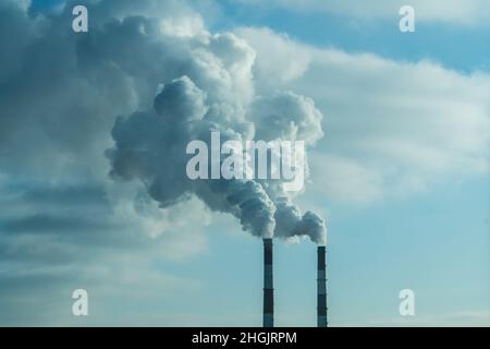 Vapore in uscita dai tubi della centrale termoelettrica in inverno. Termal Power Industry e il concetto di inquinamento ambientale e . Foto Stock