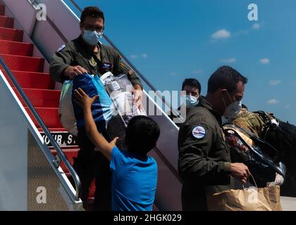 Task Force Liberty Airmen consegna il bagaglio a mano a un individuo afghano a sostegno del Dipartimento di operazione guidata dallo Stato Allees Refuge sulla base congiunta McGuire-Dix-Lakehurst, New Jersey, 25 agosto 2021. Il Dipartimento della Difesa, attraverso il comando del Nord degli Stati Uniti, e a sostegno del Dipartimento di Stato e del Dipartimento di sicurezza interna, sta fornendo trasporto, alloggio temporaneo, screening medico, e supporto generale per almeno 50,000 afghani in strutture adeguate, in strutture permanenti o temporanee, il più rapidamente possibile. Questa iniziativa fornisce al personale afghano un sostegno essenziale a Secure lo Foto Stock