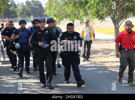 Da sinistra a destra, funzionario di pubblica sicurezza S. Kotani, Dipartimento di Sunnyvale per la pubblica sicurezza (legge), co-guida una Task Force di soccorso con l'ufficiale di polizia Alan Corpuz dal Dipartimento di polizia di Mountain View come Sgt. Edward durante, un proctor di esercizi presso l’ufficio dello sceriffo della contea di Santa Clara, cammina accanto durante l’allenamento di risposta allo sparatutto attivo, allo Sgt. James Witowski Armed Forces Reserve Center, a Mountain View, California, 26 agosto 2021. Foto Stock